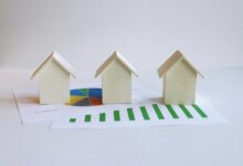 three small houses sitting on top of a piece of paper